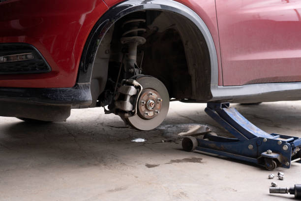 油圧ジャッキを使用して車のホイールを交換します。車のメンテナンスコンセプト。タイヤパッチの準備のために車の車輪を取り外します。車輪のないブレーキディスク。自動車修理サービ� - tire car built structure surrogate ストックフォトと画像