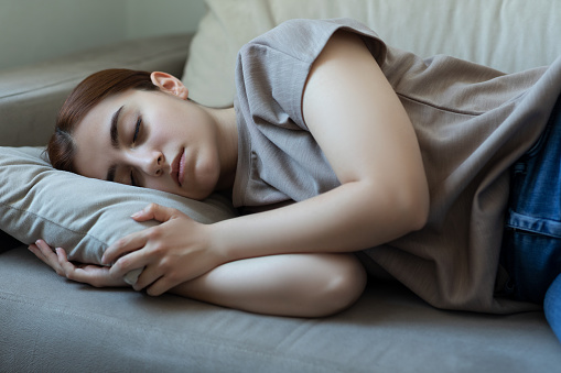 Young woman sleeping on her living room sofa