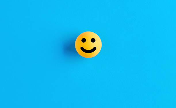 istock Smiling face emoticon or icon on a ball on blue background. Positive feedback 1325683460