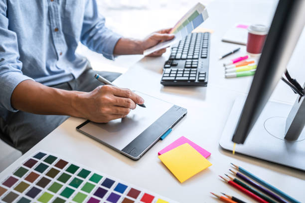 istock Image of male creative graphic designer working on color selection and drawing on graphics tablet at workplace with work tools and accessories in workspace 1325683742