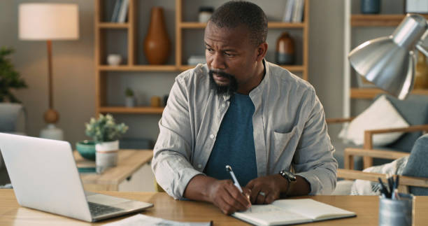 istock Shot of a mature man using a laptop and going through paperwork at home 1325684583