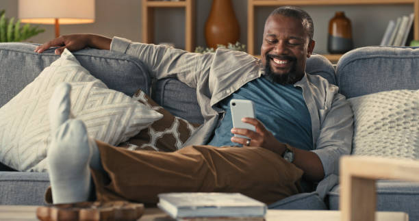 istock Shot of a mature man using a smartphone on the sofa at home 1325684598