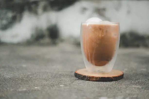 Photo of Iced mocha coffee in double wall glass on a dirty background