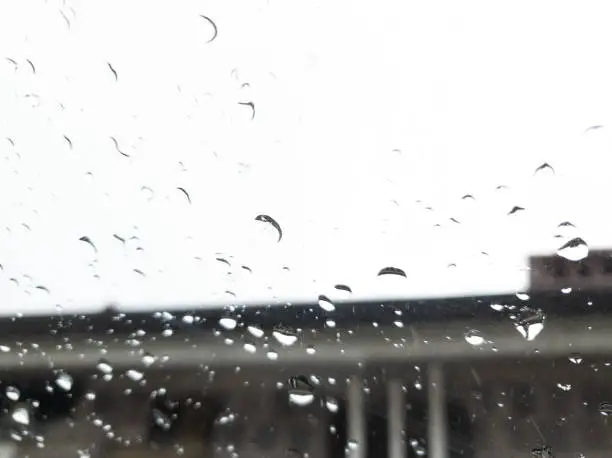 Photo of Rain droplets on a window in a rainy season.
