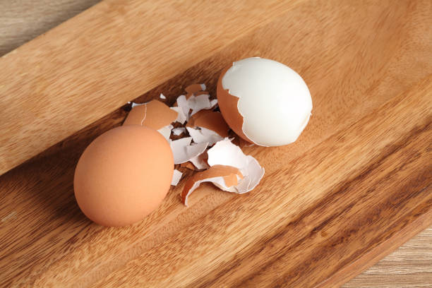 istock Chef peeling boiled egg on wooden cutting board in kitchen 1325689981