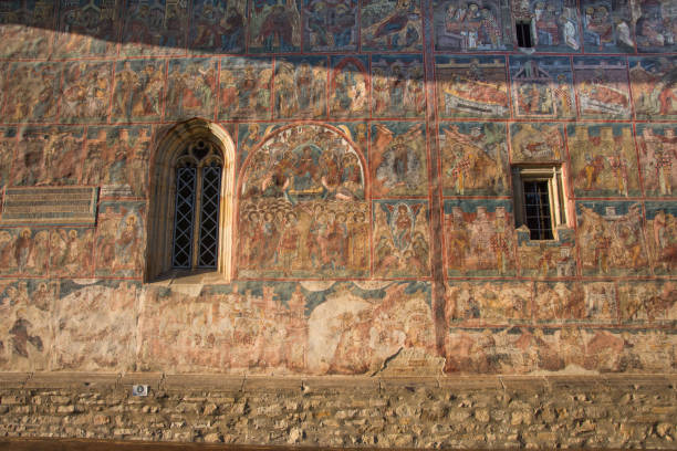 istock Painted wall at Monastery Humor, Romania ,2017,october Old window with bars 1325691237
