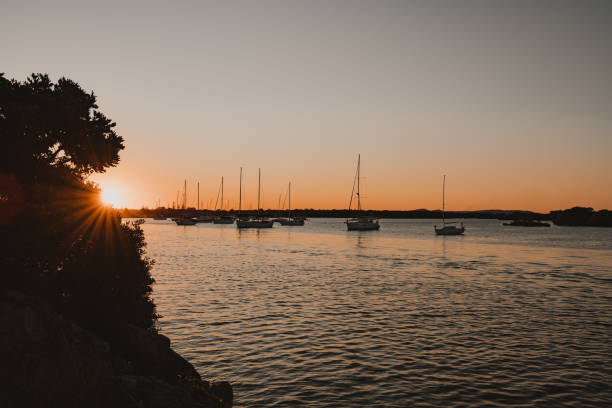 barcos y yates sentados en el río al atardecer cerca de la marina de yamba en el río clarence. - yamba fotografías e imágenes de stock