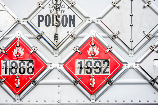 Set of the frames on the side of the semi trailer for a show information safety signs warning about the carriage of flammable or explosive or poisonous goods during semi truck transporting it