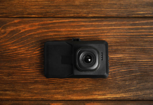 istock Modern car dashboard camera on wooden background, top view 1325697460