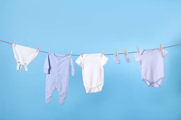 istock Clean child's clothes hanging on laundry line against light blue background 1325697502