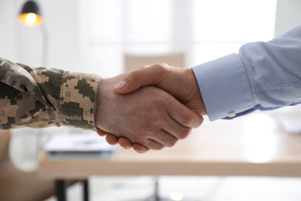 Soldier and businessman shaking hands indoors, closeup Soldier and businessman shaking hands indoors, closeup veteran stock pictures, royalty-free photos & images