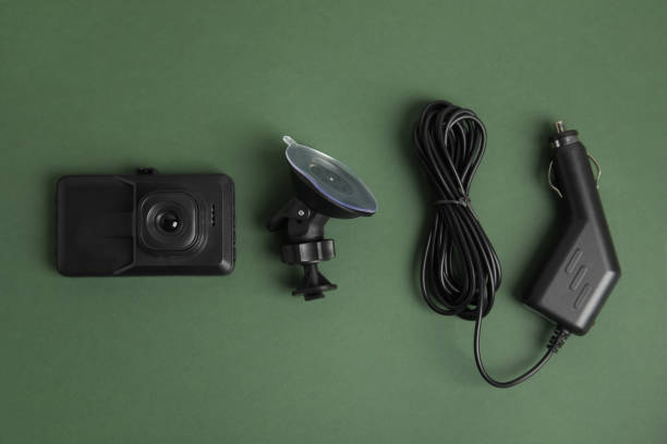 istock Modern car dashboard camera, suction mount and charger on dark green background, flat lay 1325699443
