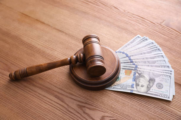 istock Judge's gavel and dollar bills on wooden table 1325699481