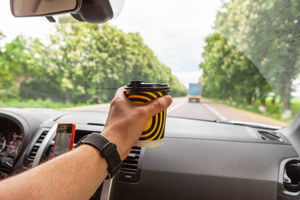 man passenger in car drinking coffee