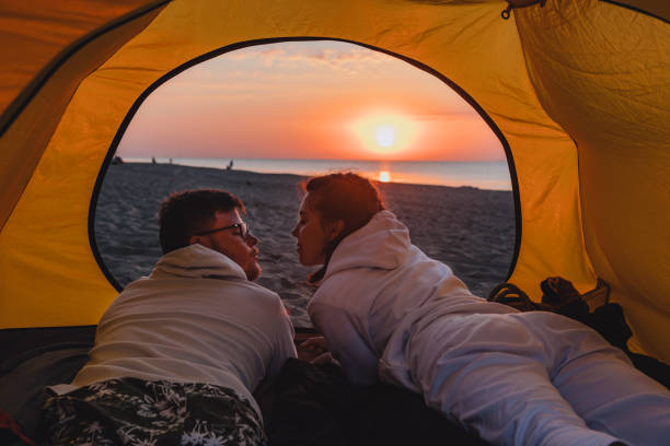 istock couple sleeping in camping tent looking at sunrise 1325701017