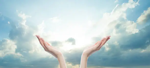 Photo of Hands reach for the sky in prayer.