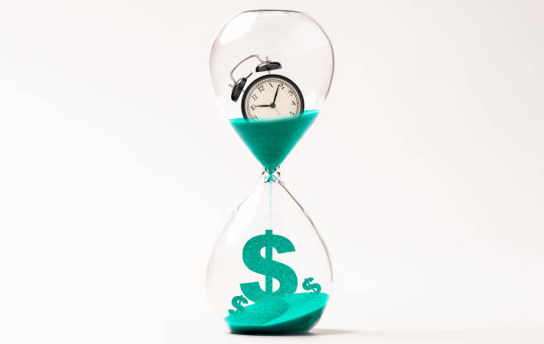 alarm clock inside hourglass and countdown to us dollar sign , money and time management concept. - time and money imagens e fotografias de stock