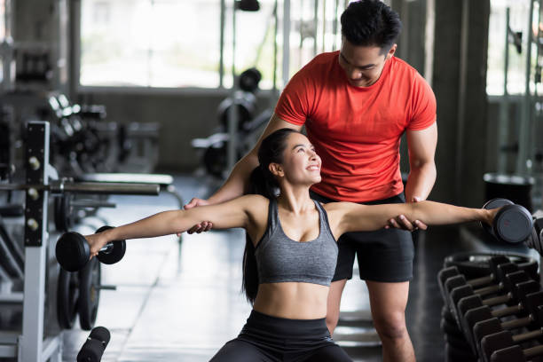 istock Happy couple training bicep dumbbell together in gym 1325705345