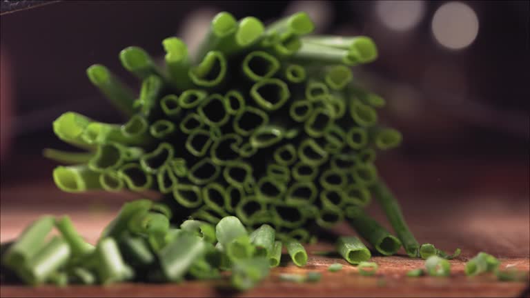 Cutting fresh green onions on a cutting board.