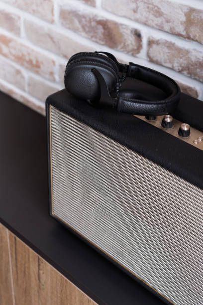 istock Headphones on stereo speaker on dark brown shelf 1325707933