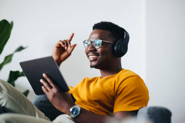 istock Work From Home:Young African American With Headphones Using Tablet 1325708022