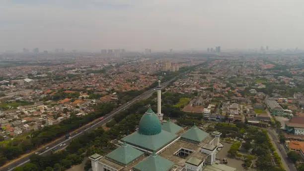 aerial view cityscape city Surabaya with mosque Al Akbar, highway, skyscrapers, buildings and houses. mosque in Indonesia Al Akbar in Surabaya, Indonesia. beautiful mosque with minarets on island Java Indonesia.