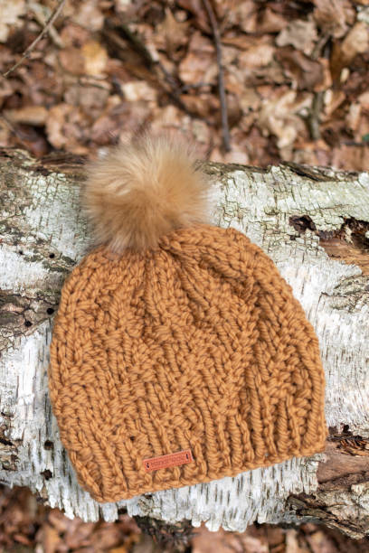 istock Hand knit pompom hats with forest woodland background 1325708885