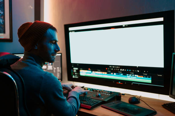 istock Male Video Editor Working on His Personal Computer with Big blank Display 1325708962