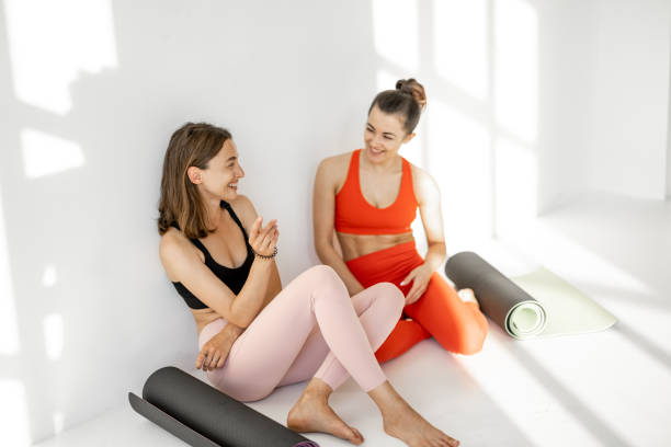 istock Two girlfriends talk on a yoga break indoors 1325709102