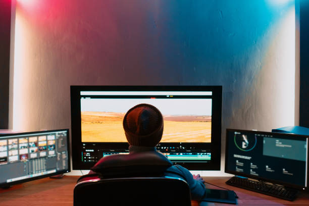 männlicher video-editor arbeitet auf seinem personal computer mit großem display - bildart stock-fotos und bilder