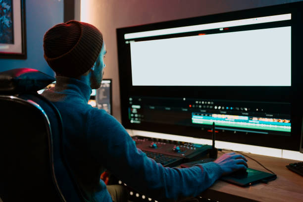 istock Male Video Editor Working on His Personal Computer with Big blank Display 1325709288