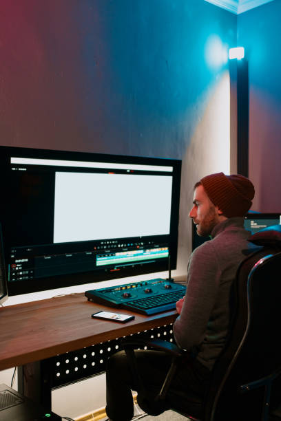 istock Male Video Editor Working on His Personal Computer with Big blank Display 1325709315