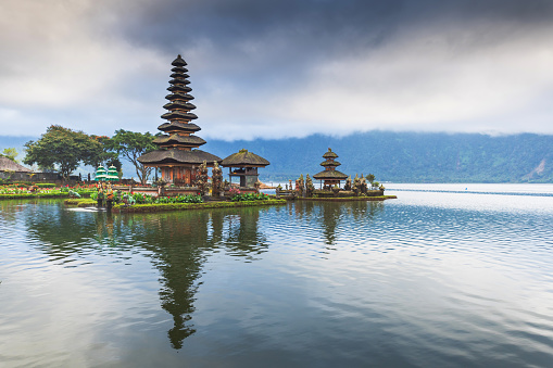 Pura Ulun Danu hindu temple on lake Beratan, Bali,  in the early morning surrounding mountains , creating an aura of spiritual mystery.