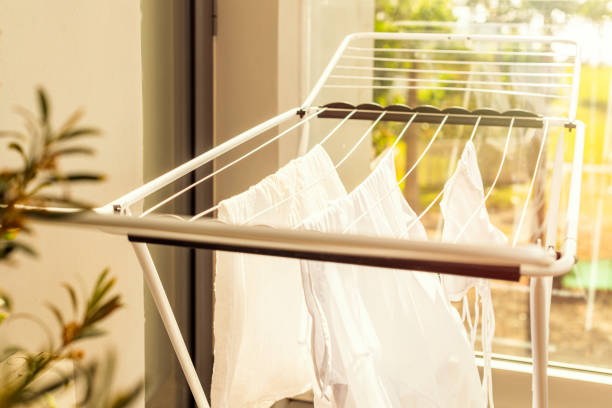 hanging laundry on balcony on the drying rack opposite sea and palm trees view at sunset sunshine - secar imagens e fotografias de stock