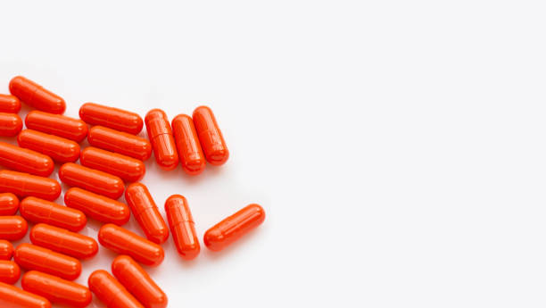 istock Orange capsule pills on white background. 1325713368