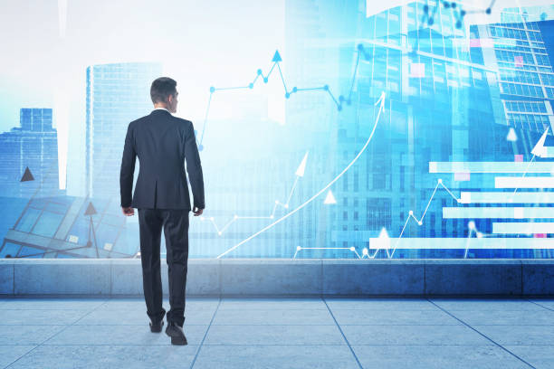 istock Man standing on roof looking at city with charts 1325714616