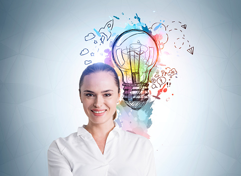 Businesswoman portrait with happy and confident look, bulb with colourful sketch and doodle symbols. Illustration on blue background. Concept of start up and new ideas