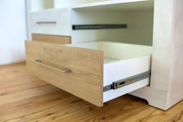 Photo of Close up of wooden drawer in contemporary cupboard cabinet.