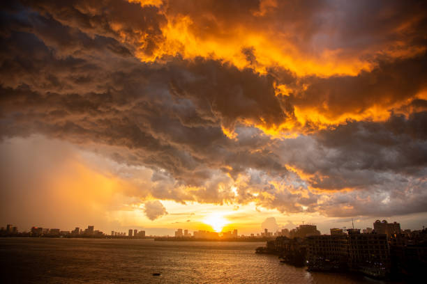 dense storm clouds build up at sunset as seen looking NW across West Lake in Hanoi