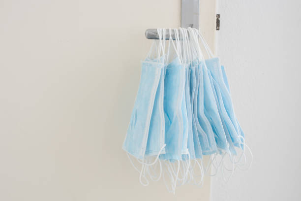 istock many used corona face masks hanging from a door handle. 1325716715