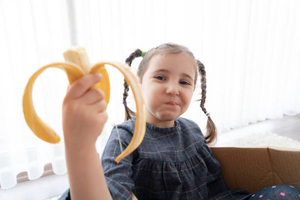 istock Little girl eating a banana 1325717064