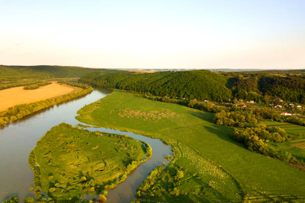 istock Aerial view of bright river flowing through green meadows in spring. 1325718437