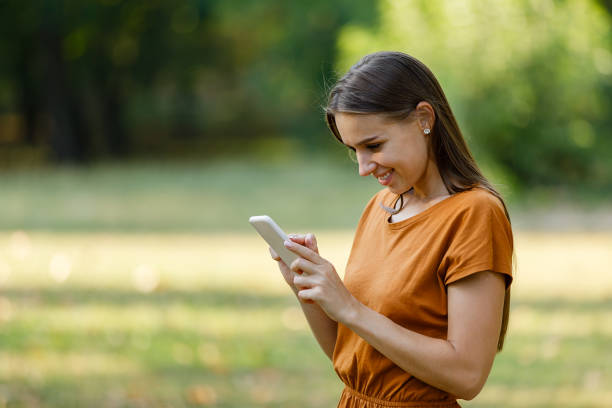 istock A Young Woman is Walking in Nature and Using a Smart Phone. 1325719420