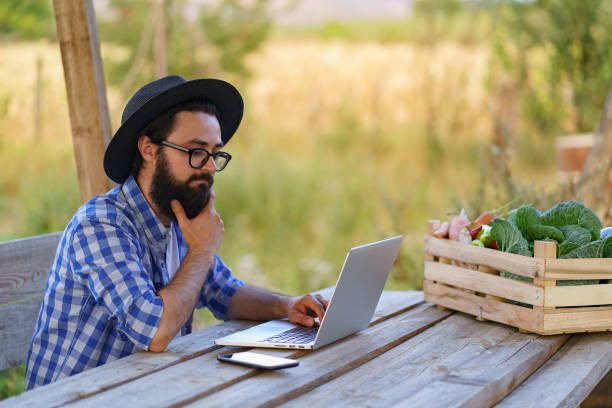 фермер, использующий технологии для продажи своей продукции - farmer laptop selling internet стоковые фото и изображения