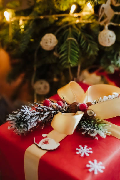 istock beautifully wrapped red gift box under the christmas tree, top view 1325720635