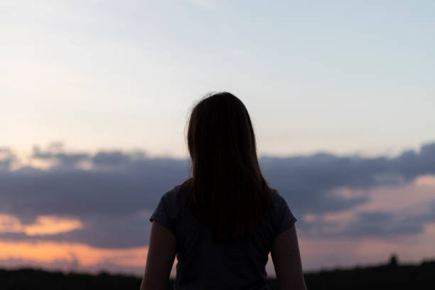 istock Young woman looks at the sunset. 1325722175