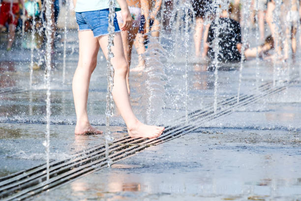 噴水からの水のジェットの飛沫で女性の素足に選択的に焦点を当てます。 - wet dress rain clothing ストックフォトと画像