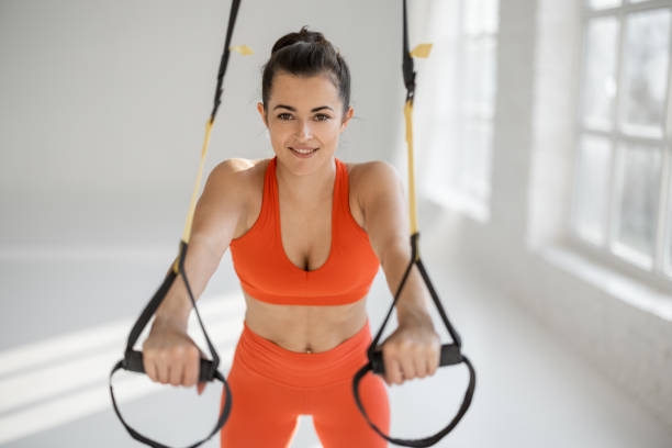 istock Sportswoman doing push ups on TRX straps 1325724297