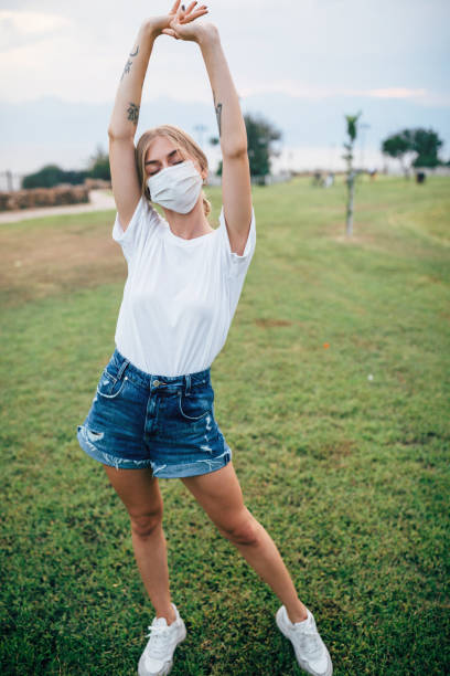 istock Beautiful smiling woman behind face protection mask 1325726505