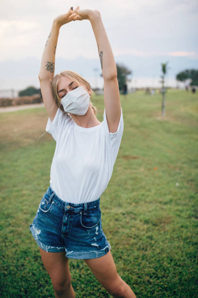 istock Beautiful smiling woman behind face protection mask 1325726533